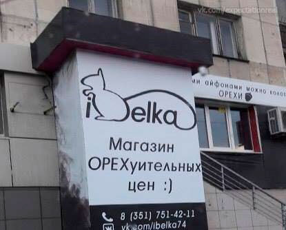 Вывеска магазина iBelka с силуэтом белки и надписью “Магазин ОРЕХуительных цен :)” на стене здания.