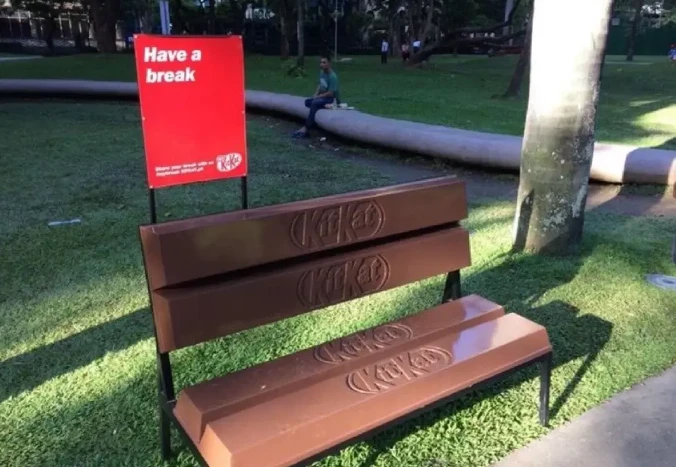 Скамейка KitKat в парке с надписью на красном фоне